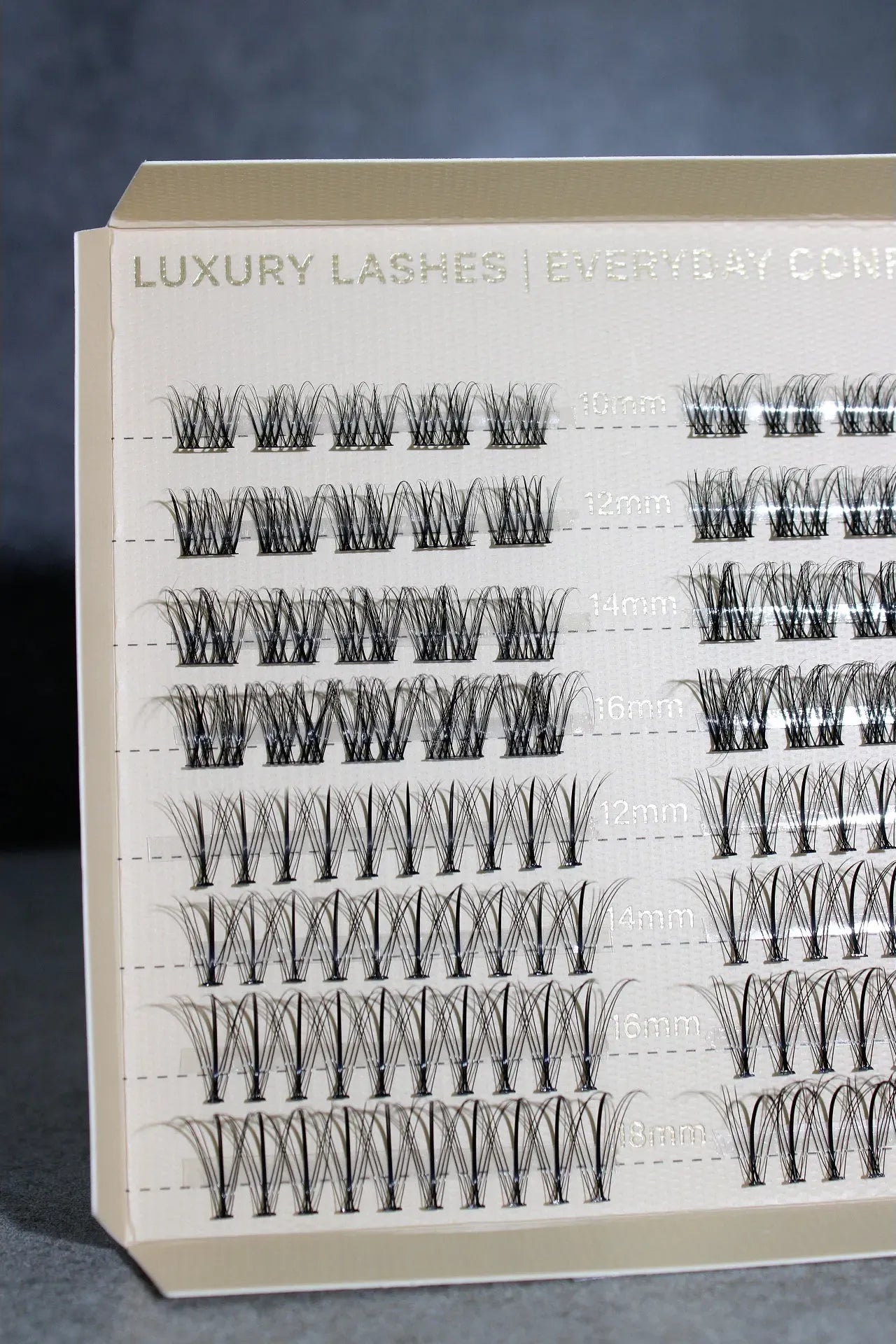 Eyelash extension kit with various styles on a gray background