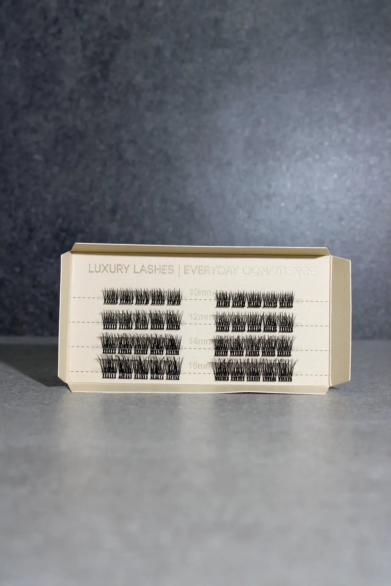 Eyelash extension tray with multiple rows of lashes on a gray background