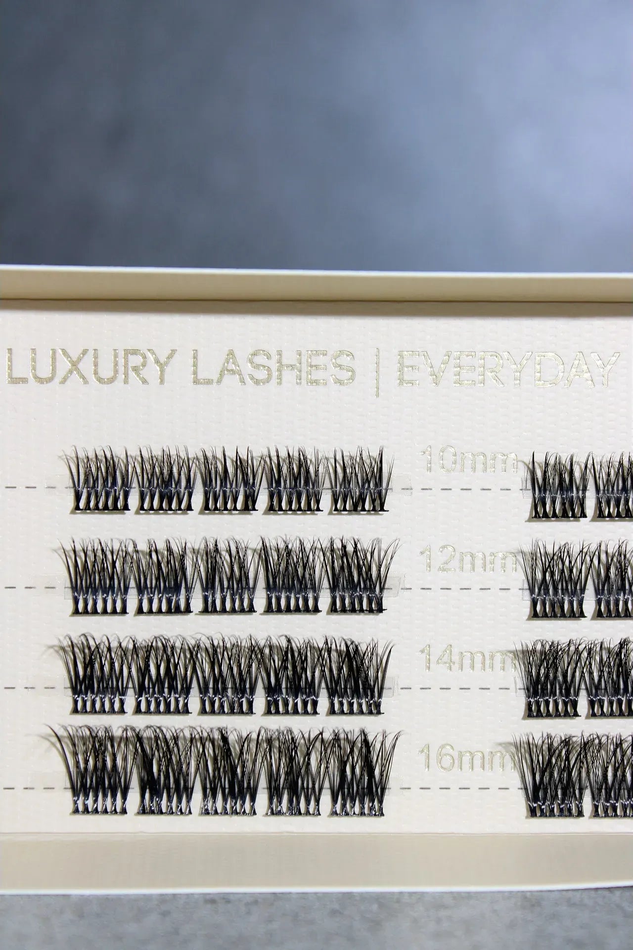 Set of false eyelashes with measurement chart on a gray background