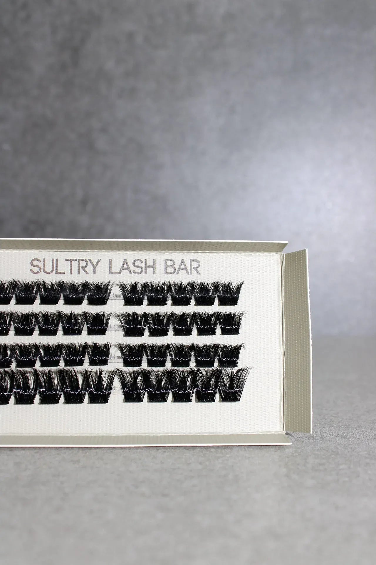 Eyelash extension tray with 'Sultry Lash Bar' branding on a gray background