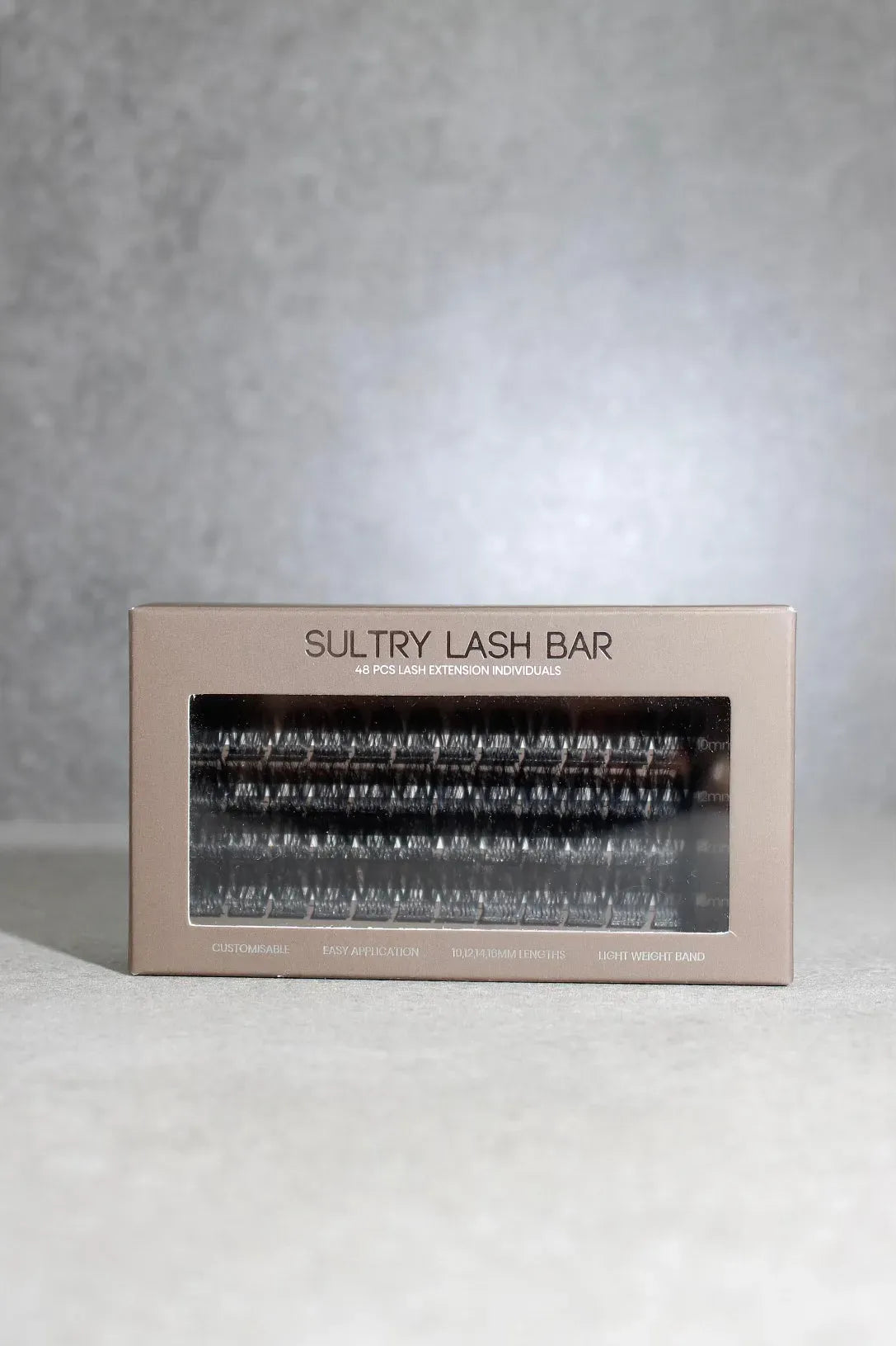Sultry Lash Bar packaging with false eyelashes on a gray background