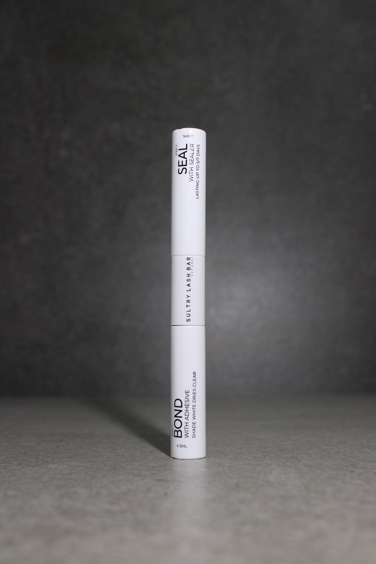 White cylindrical object with text on a dark textured background