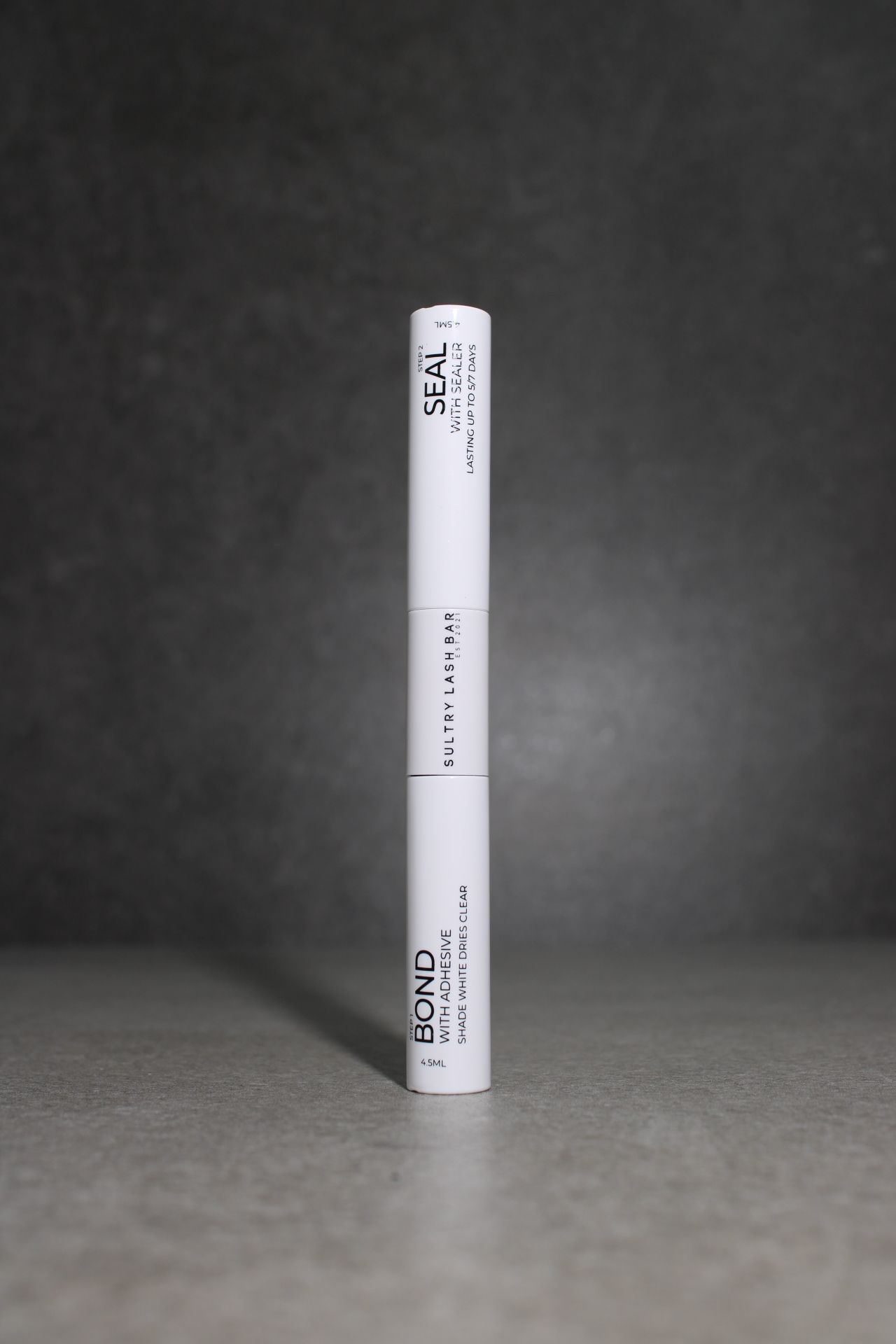 White cylindrical object with text on a dark textured background