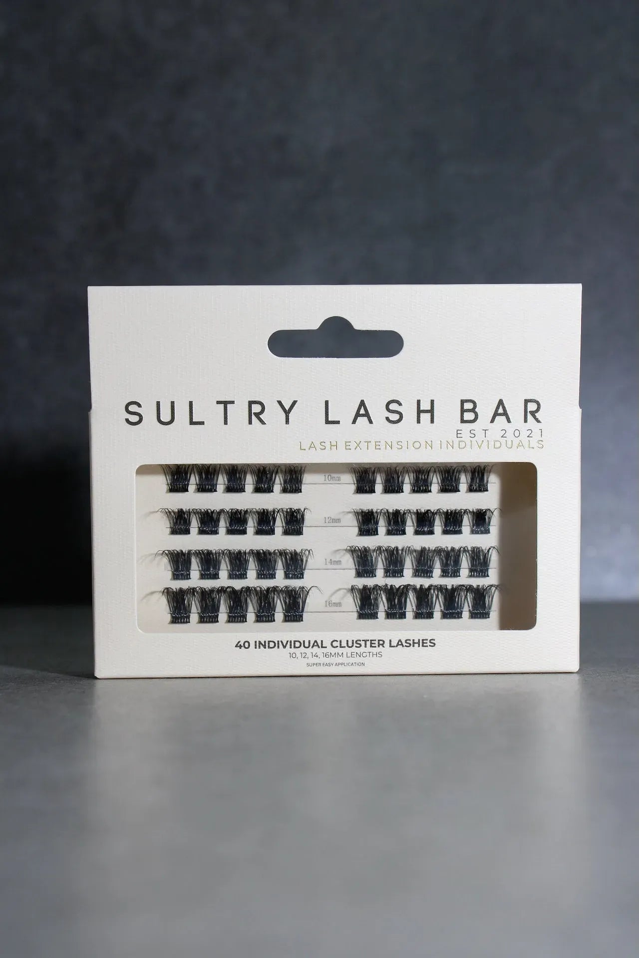Packaging of Sultry Lash Bar lash extensions on a dark background
