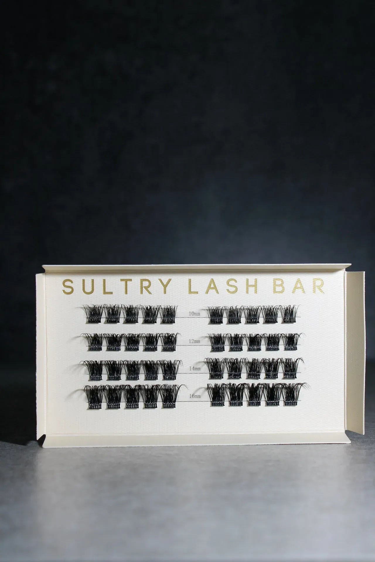 Eyelash extension tray with 'Sultry Lash Bar' branding on a dark background