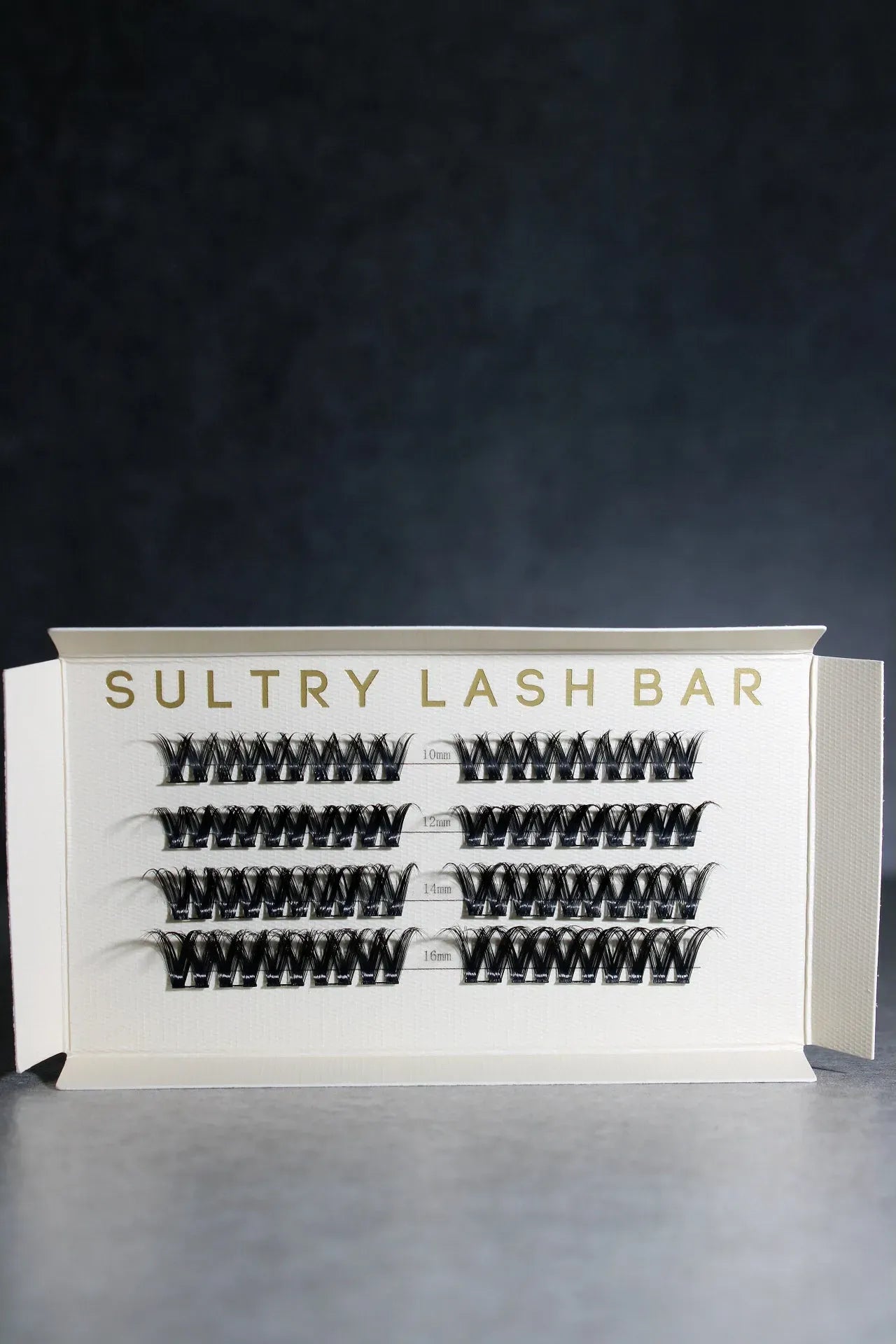 Sultry Lash Bar packaging with false eyelashes on a dark background