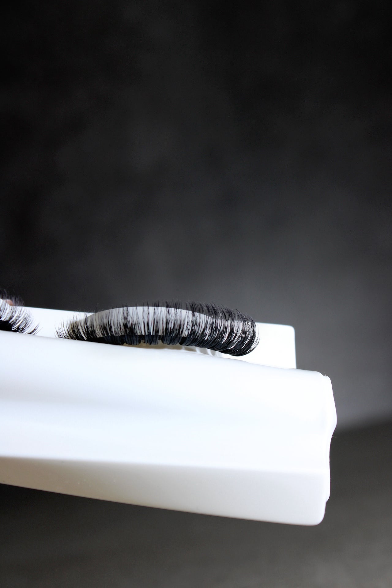 False eyelashes on a white surface with a dark background