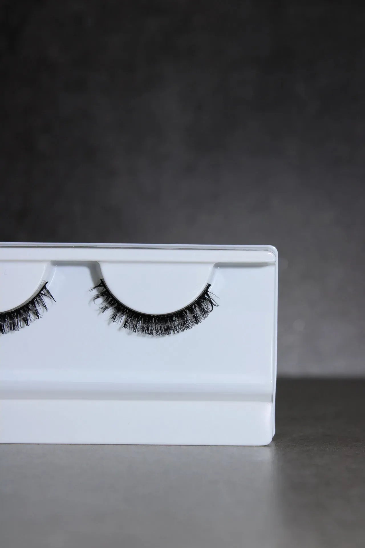 Eyelashes in a white box on a dark background