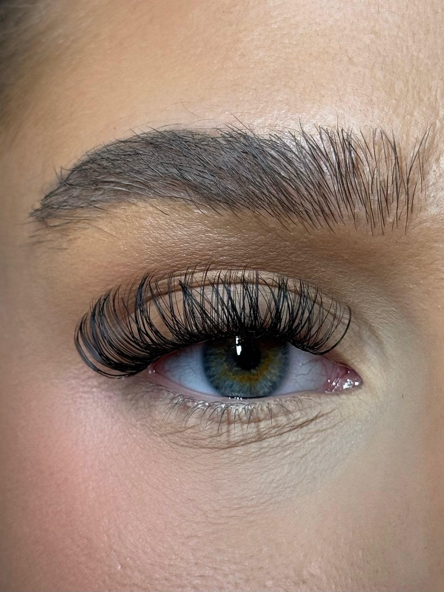 Close-up of beautifully applied DIY eyelash extensions showcasing volume and natural eye color.