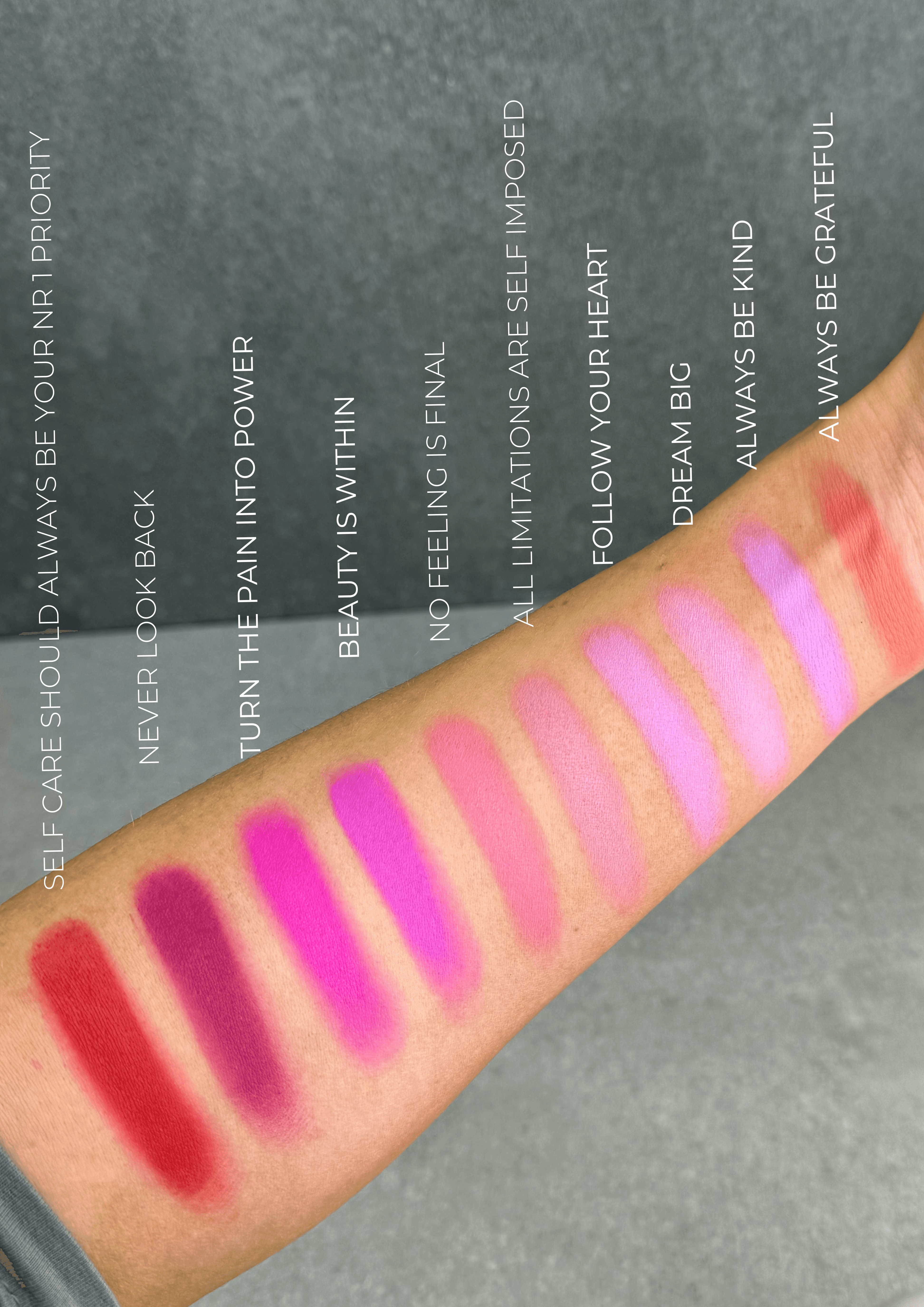 Arm swatches of 12 high-pigment powder blush shades labeled with empowering names, showing blendable and buildable color payoff.