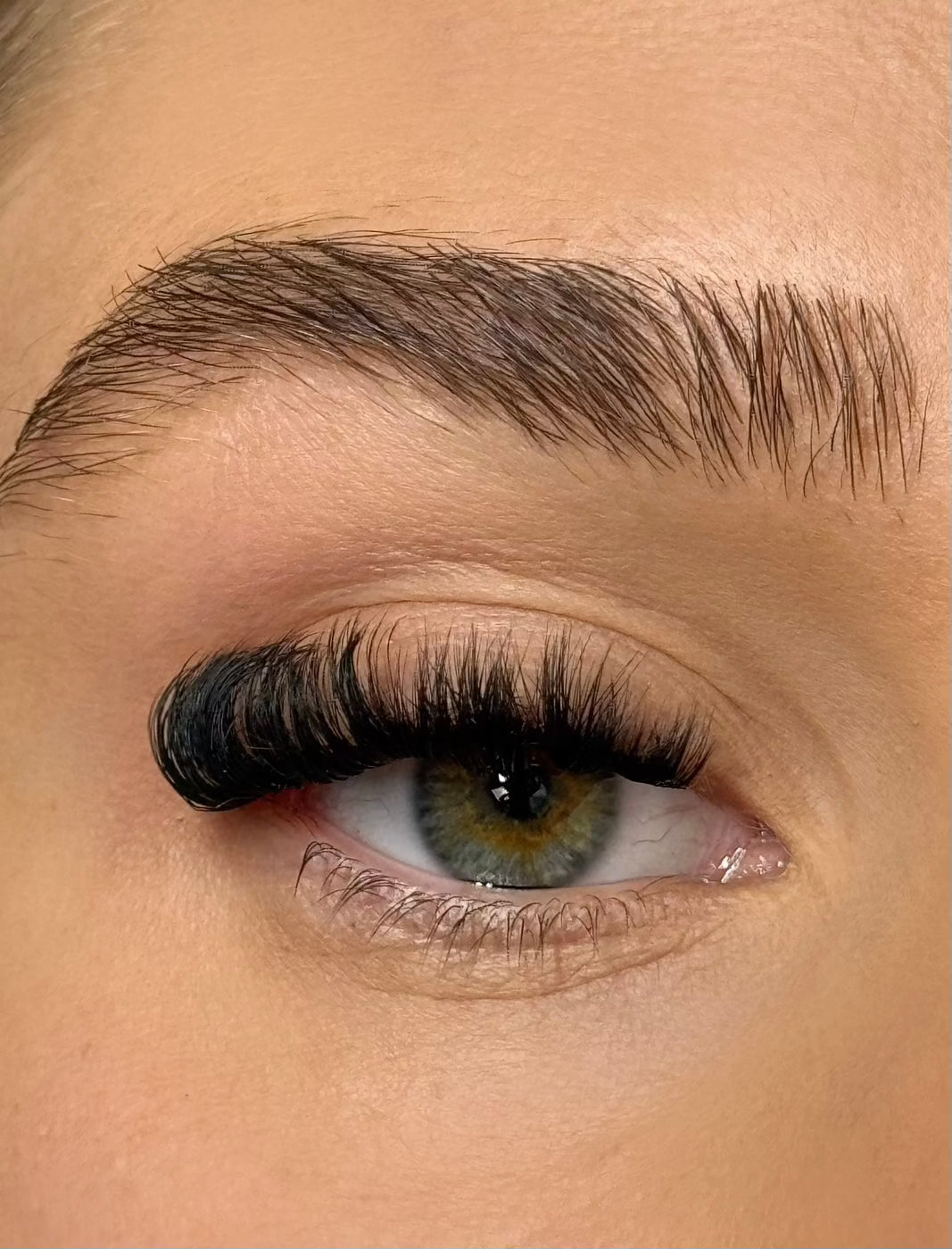 Close-up of an eye with DIY long-lasting individual eyelash extensions applied, enhancing natural lashes for a fuller, voluminous look.