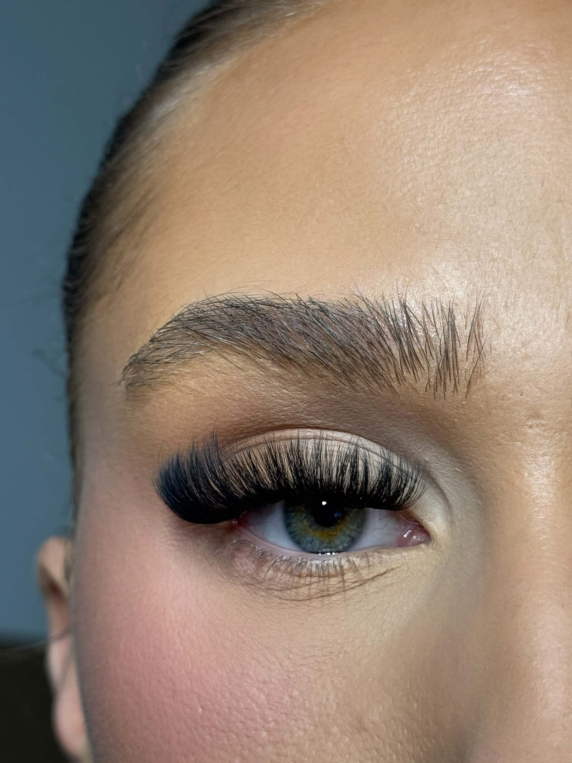 Close-up of eye with full, natural-looking hybrid lash extensions enhancing beauty and elegance.